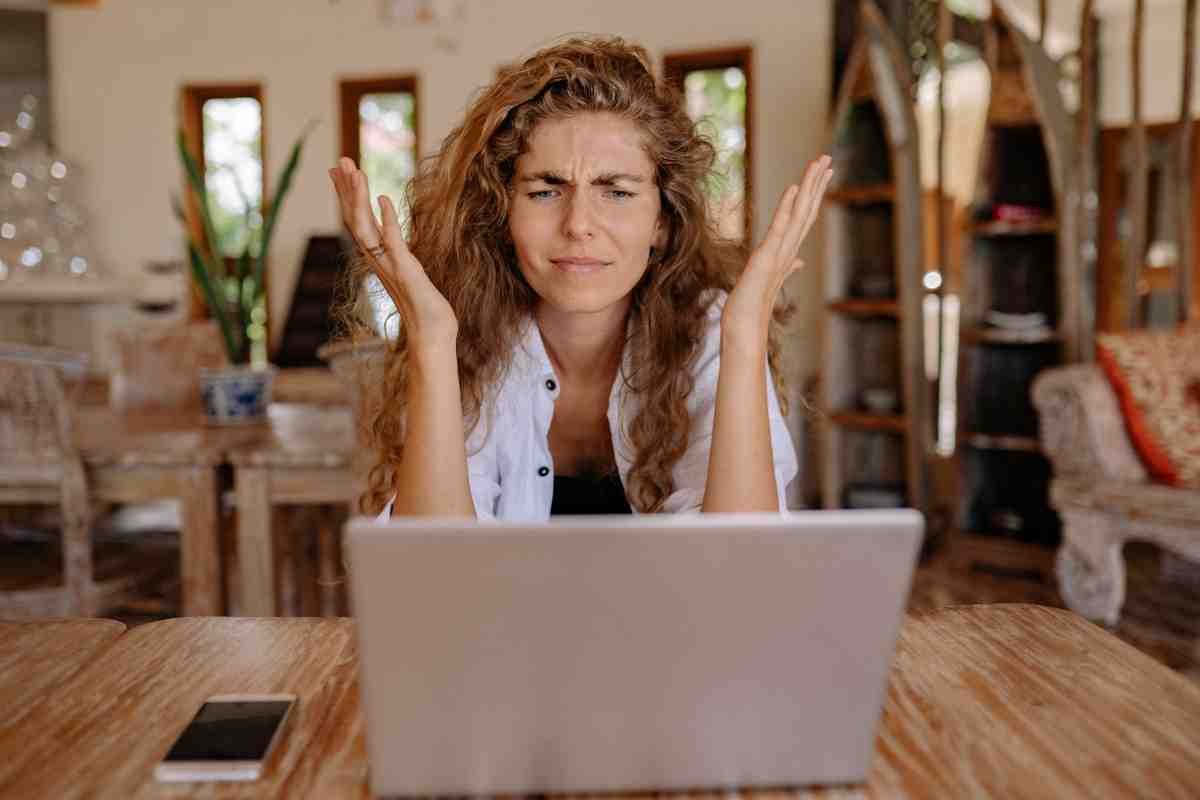 emotional response and status woman with her hands in the air looking cross at a computer screen